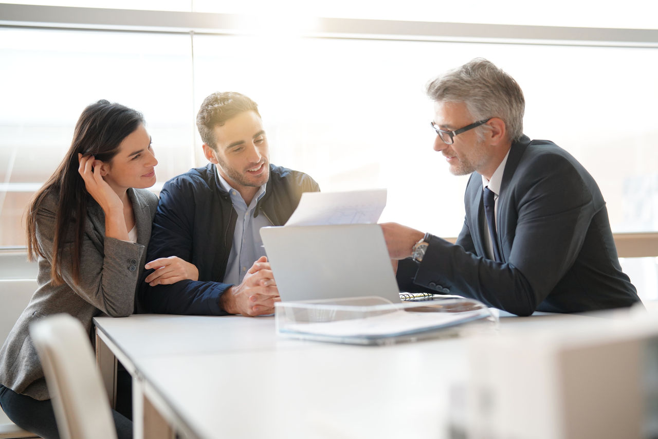 Young couple meeting financial advisor for home investment