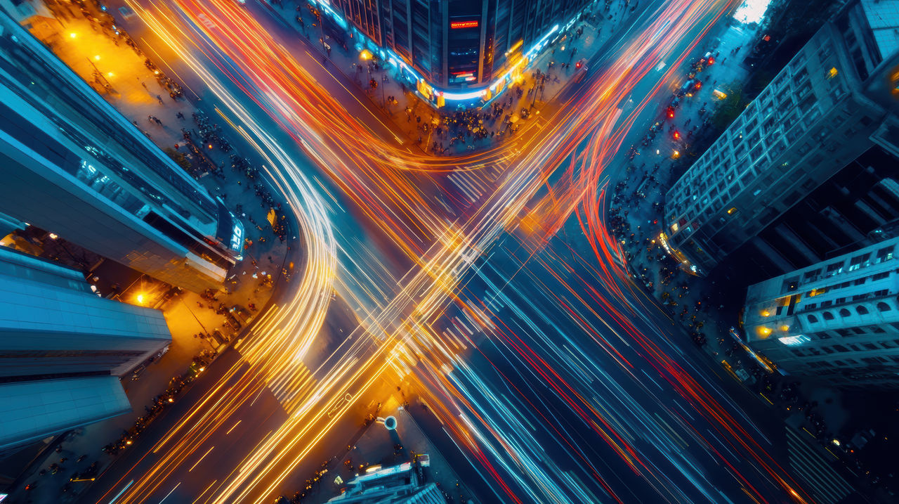 a timelapse of a busy urban intersection with people and vehicles moving in all directions, a sense of the constant motion and energy of city life